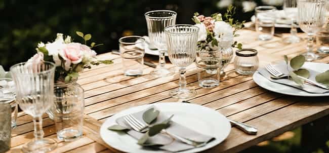 Outdoor table set with linens, glassware, and florals